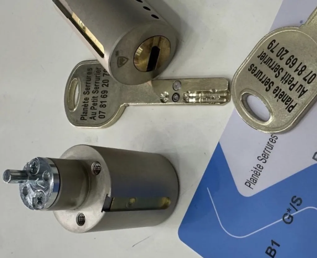 Cylindre adaptable de très haute sûreté avec clés gravées « Planète Serrures · Au Petit Serrurier » et carte de propriété nominative, gravure laser du numéro d'urgence sur chaque clé